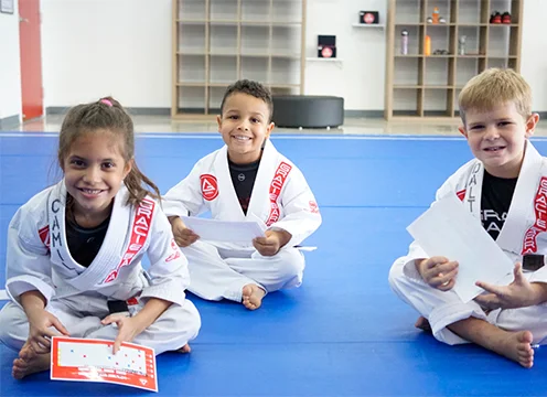 Children smiling together on the mats at Gracie Barra Kissimmee